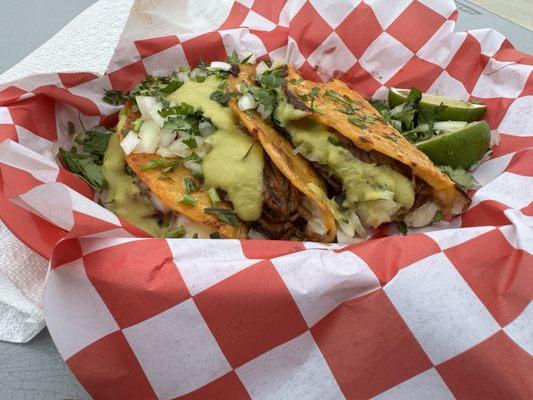 Birria tacos with green salsa added