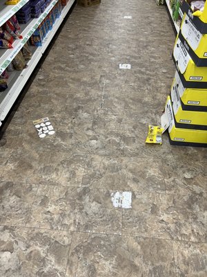 Garbage on the floor in every aisle of the store