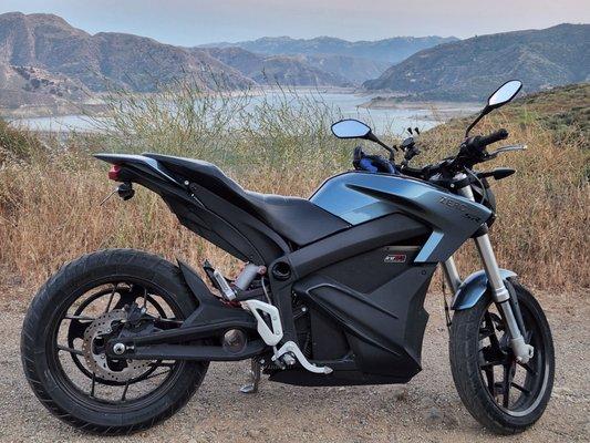 Electric Motorcycle parked next to a reservoir