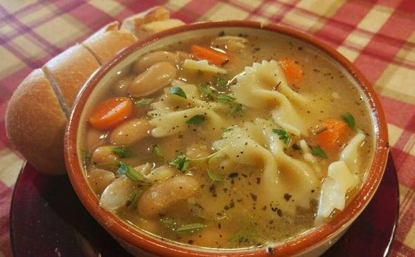 Homemade white pasta fagioli soup. Seasoned with garlic and fresh herbs. Served with toasted bread for dipping.