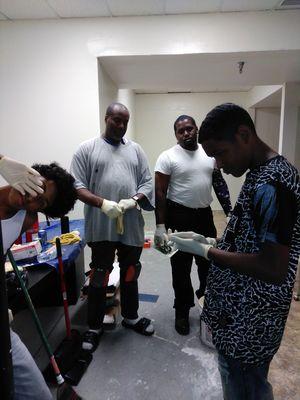 Pastor teaching young men to lay a floor.