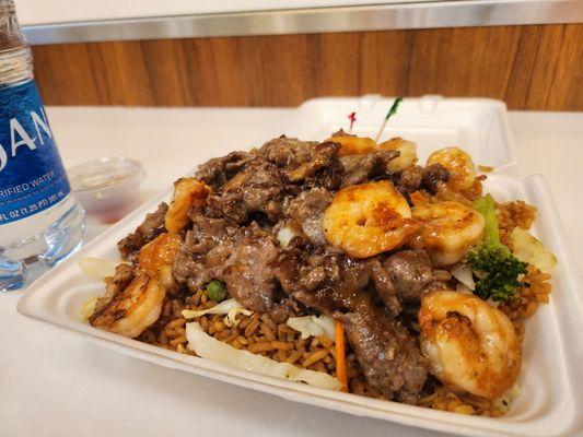 Beef and shrimp cook on teppanyaki grill