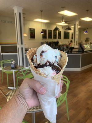 2 scoops of Manasquan Munchies with hot fudge topping in a waffle cone