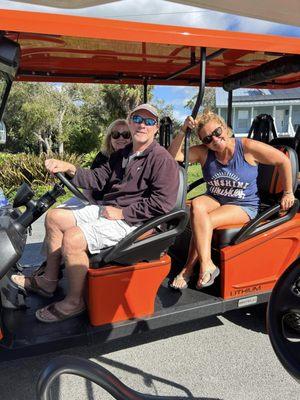 The new 6-seater golf cart in orange with friends.