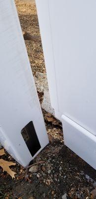 The post is cracked at the top and the post cap was shattered. You can see where they tried propping up the fence with stones.