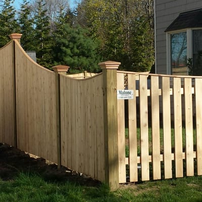 Cedar board fence with pressure treated posts.