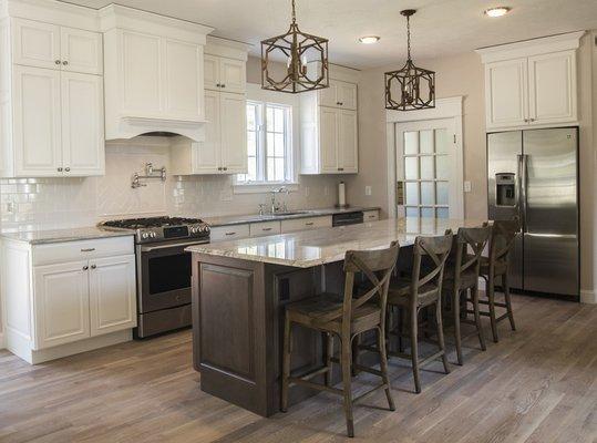 White stacked wall cabinets, a wood hood, Cherry island and a reclaimed French door in Holliston