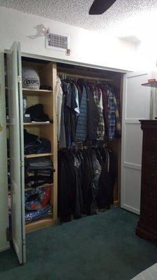 Custom mens closet with bi-fold shaker 3 panel doors.