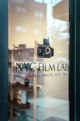 Storefront window of NYC Film Lab's 321 Starr Street location.