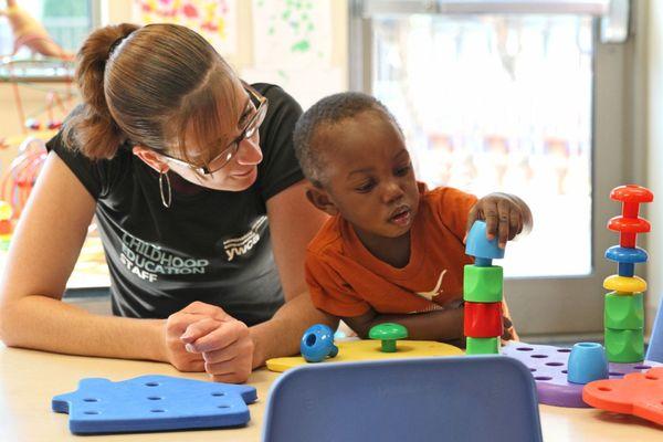 Teacher and child playing with toys.