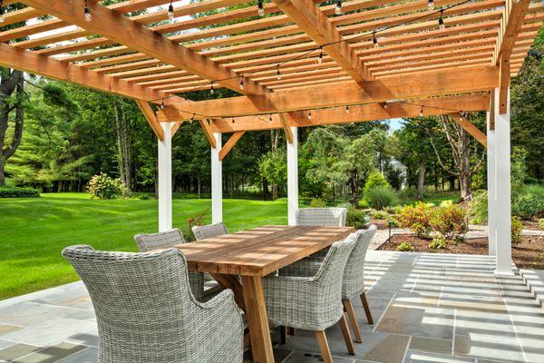 Stepping-stones lead you to the raised bluestone patio with a custom pergola with posts wrapped in Azek