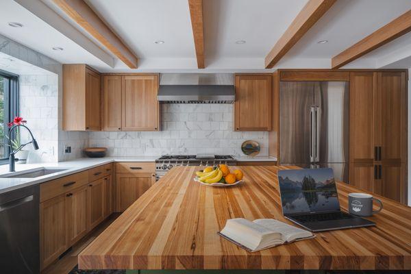 A beautifully integrated kitchen and dining space, featuring rich wooden accents and contemporary fixtures.