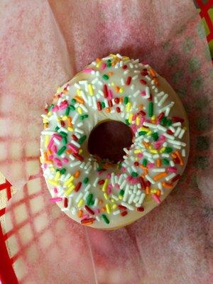 White iced glazed donut with sprinkles.