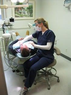 Our wonderful hygienist, Melissa, happily caring for a patient!