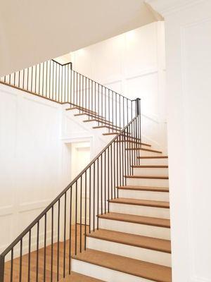 White oak solid steps with paint grade solid risers iron railing with wainscoting