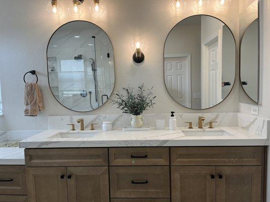 Master bath with quartz counter and gold and black accessories