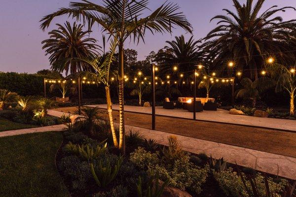 Outdoor backyard bocce court in Hope Ranch with bistro lights.