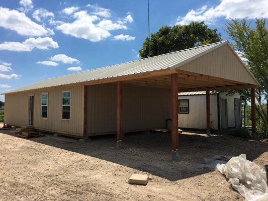 Storage building with covered area for equipment.