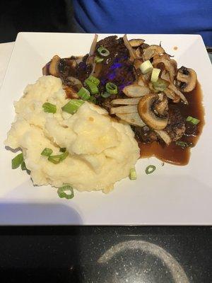 Meatloaf with onion, mushrooms and gravy. Mash in the side. It grows on you.