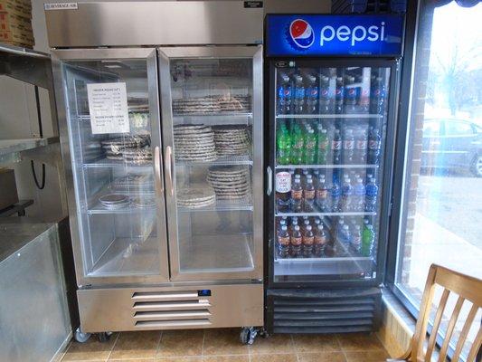 Coolers with frozen pizzas to-go and soda in 20 oz bottles.