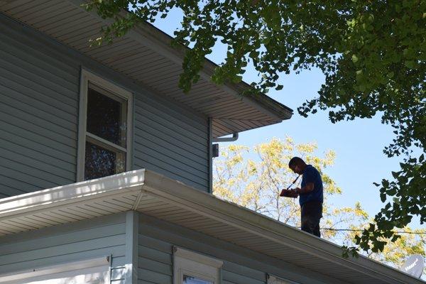 Ryan is checking out the roof, shingles, siding, windows, soffit, facia, gutters and more from this vantage point.