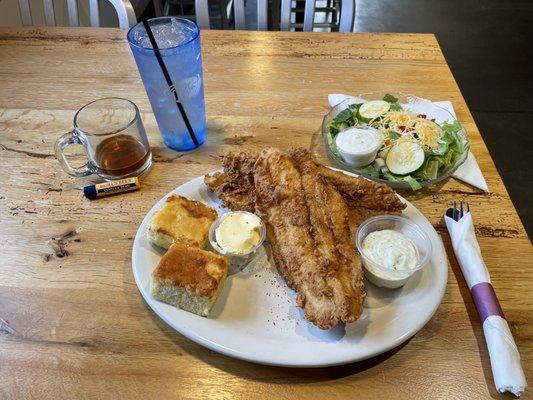 Catfish (fried) platter with tartar sauce. On side, cornbread with whipped butter and small salad with blue cheese dressing.