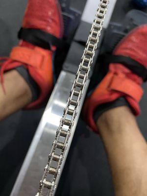 A rowing machine chain and weight lifters shoes