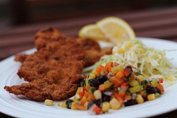 Chicken milanesas with summer salad and cabbage & corn salad