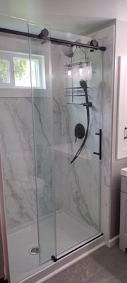 Beautiful install of shower doors, walls, shower heads, and window.