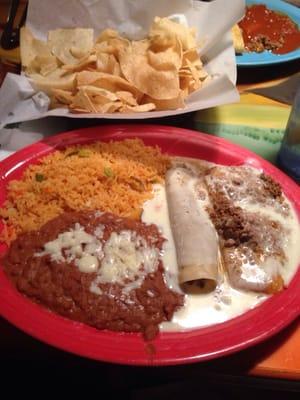 Enchilada, Tamale, Rice & Beans with cheese sauce.