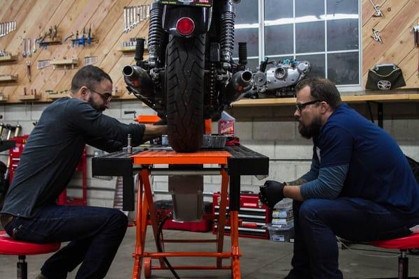 A couple of members teaming up during an Intro to Moto Maintenance Class!