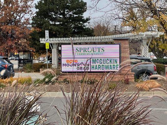 Main entrance at Arapahoe, sign cycles with various stores featured.