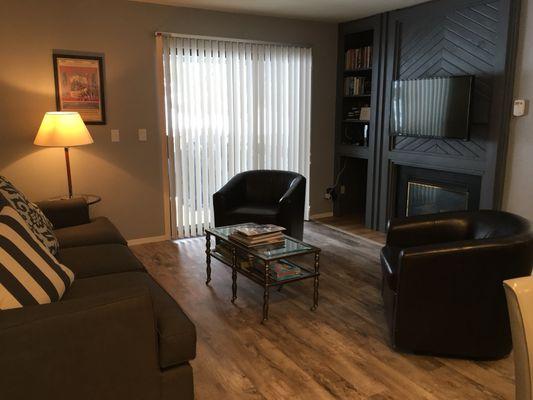 Living room with cozy fireplace and patio with BBQ