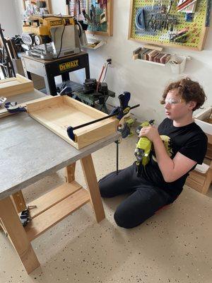 Kids use drill, sander, mitersaw, nailgun (age appropriate)