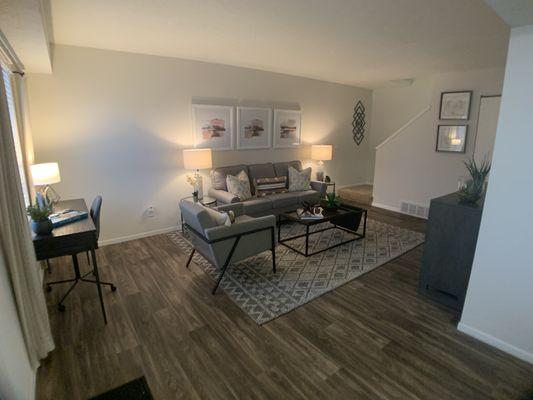 Spacious living room with solid surface faux wood flooring throughout.