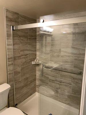 Finished bathroom handicap accessible bar soap dish in corner brush nickel shower door.