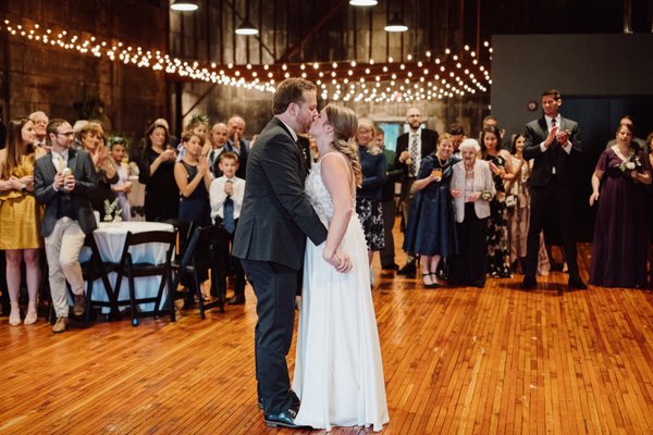 Bride and groom share first dance and kiss  at Olio modern industrial event space north of Boston Massachusetts, New England