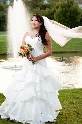 I love this photo of Daisy as her veil takes flight in the breeze at her wedding! Photo by Clapp Studios.