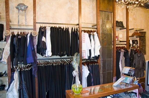 the front room showing some of the clothing racks and the ceiling to floor slate waterfall