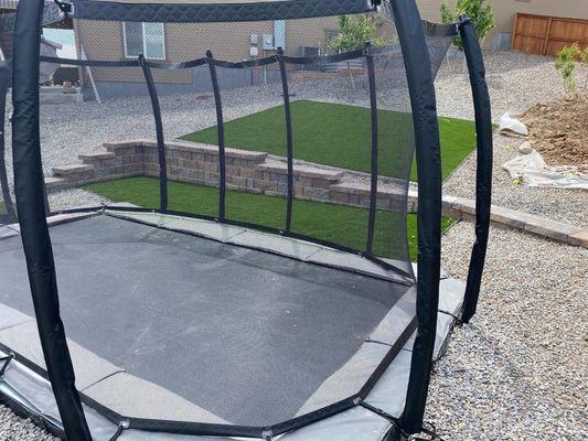 Underground trampoline, block wall, rock and artificial grass installation.