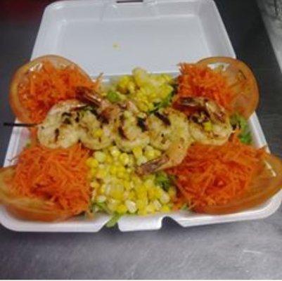 Shrimp Salad grilled House Seasoned Shrimp on a bed of Lettuce topped with Fresh Corn, Shredded Carrots and Tomato.