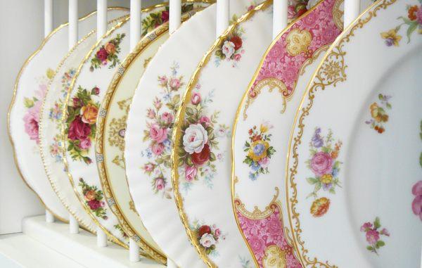 Our mismatched vintage dinner plates are made of porcelain, adorned with delicate colorful flowers and accented with lustrous gold banding.