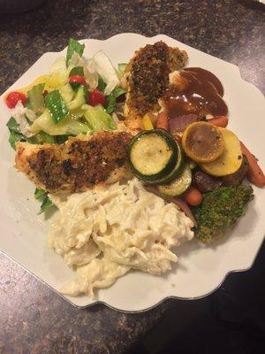 Delicious Parmesan Crusted Chicken with pasta alfredo, mixed veggies, salad, and other sides.