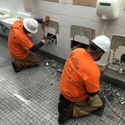 Opening up cinderblock walls to gain access to the plumbing