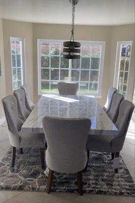 Large marble table with Michael Amini and Kathy Ireland designer chairs.