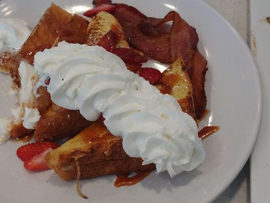 French toast with fresh strawberries and whipped topping.