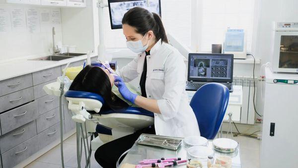 dentist providing dental cleaning to patient