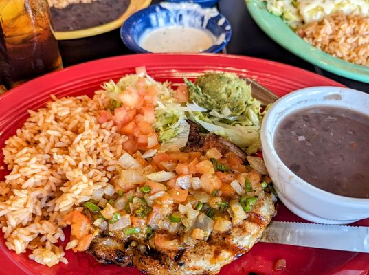 Grilled pork chop spiced perfectly with rice and black beans.