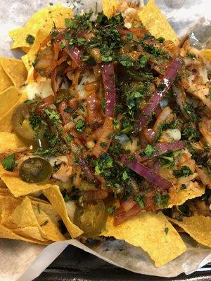 "Pulled Pork Nachos" Mountain of Pulled Pork, Jalapenos, Cheese Sauce, Red Onions, and Cilantro.