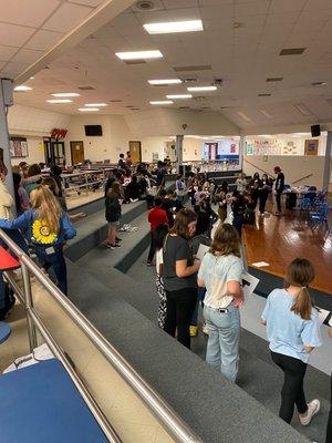 Weekly large group meeting on school campus.